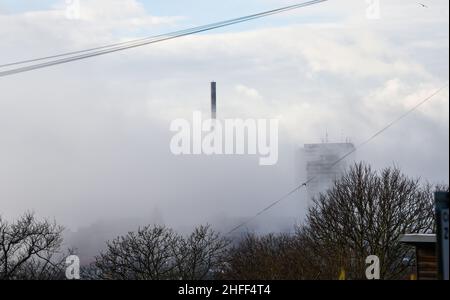 Brighton UK 16th January 2022 - Nebel rollt von der Strandpromenade von Brighton und den Sussex Heights-Wohnungen über dem Stadtzentrum ein, da für Großbritannien in den nächsten Tagen ein eher sesshaftes Wetter prognostiziert wird: Credit Simon Dack / Alamy Live News Stockfoto