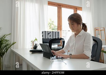 Asiatische junge Frau arbeiten auf digitalen Tablet zum Lernen Bildungskurs oder Ausbildung, Seminar, Bildung online zu Hause Konzept Stockfoto