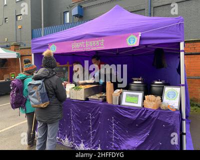 Vegetarier Markt im Wolverton Milton Keynes UK Vegan Zelt Essen verkaufen Kunden lila Zelt Rucksäcke warmes Essen außerhalb der Stände Stockfoto