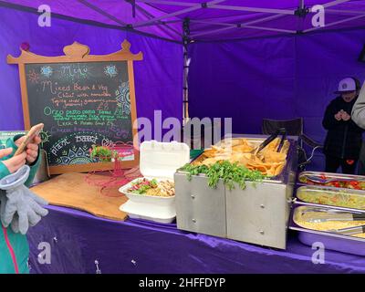 Vegetarier Markt im Wolverton Milton Keynes UK und veganisches lilafarbenes Speisezelt außerhalb des Stalls, das für hungrige Kunden zum Verkauf angeboten wird Stockfoto