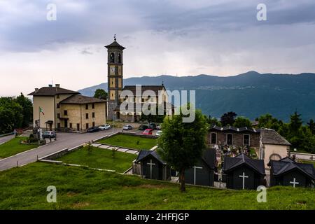 Die örtliche Kirche von Fuipiano Chiesa di San Giovanni Battista und der angeschlossene Friedhof, der in der Ferne Hügel umgab. Stockfoto