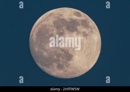 London, Großbritannien. 16th Januar 2022. UK Wetter: Mondaufgang 98,4% Wachsen der Gibbons steigt um 16:13 Uhr über London City. Kredit: Guy Corbishley/Alamy Live Nachrichten Stockfoto