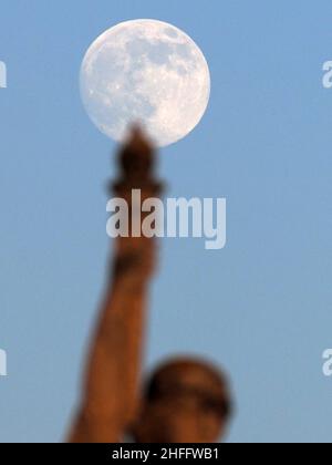 Sheerness, Kent, Großbritannien. 16th Januar 2022. Wetter in Großbritannien: Der fast volle Wolf Moon erhebt sich heute Nachmittag hinter der Freiheitskriegs-Gedenkstatue in Sheerness, Kent. Kredit: James Bell/Alamy Live Nachrichten Stockfoto