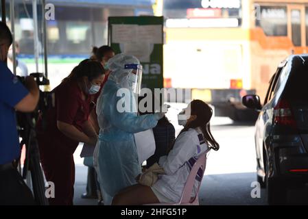 Bangkok, Thailand. 15th Januar 2022. Mitarbeiter des Gesundheitswesens der Stadtverwaltung von Bangkok, die PSA-Uniformen tragen und am 15. Januar 2022 am Bangkok Bus Terminal in Bangkok, Thailand, mit dem Rapid Antigen Test ein Wattestäbchen verwenden, um Proben von Personen zu sammeln, die Gefahr laufen, Covid-19 an öffentlichen Servicestellen sowohl im Drive-Thru- als auch im Walk-in-Format zu erreichen. (Foto von Teera Noisakran/Pacific Press/Sipa USA) Quelle: SIPA USA/Alamy Live News Stockfoto