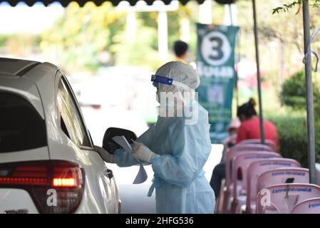 Bangkok, Thailand. 15th Januar 2022. Mitarbeiter des Gesundheitswesens der Stadtverwaltung von Bangkok, die PSA-Uniformen tragen und am 15. Januar 2022 am Bangkok Bus Terminal in Bangkok, Thailand, mit dem Rapid Antigen Test ein Wattestäbchen verwenden, um Proben von Personen zu sammeln, die Gefahr laufen, Covid-19 an öffentlichen Servicestellen sowohl im Drive-Thru- als auch im Walk-in-Format zu erreichen. (Foto von Teera Noisakran/Pacific Press/Sipa USA) Quelle: SIPA USA/Alamy Live News Stockfoto