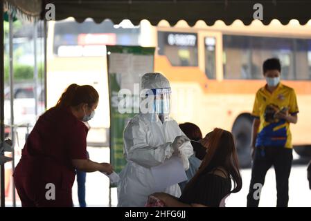 Bangkok, Thailand. 15th Januar 2022. Mitarbeiter des Gesundheitswesens der Stadtverwaltung von Bangkok, die PSA-Uniformen tragen und am 15. Januar 2022 am Bangkok Bus Terminal in Bangkok, Thailand, mit dem Rapid Antigen Test ein Wattestäbchen verwenden, um Proben von Personen zu sammeln, die Gefahr laufen, Covid-19 an öffentlichen Servicestellen sowohl im Drive-Thru- als auch im Walk-in-Format zu erreichen. (Foto von Teera Noisakran/Pacific Press/Sipa USA) Quelle: SIPA USA/Alamy Live News Stockfoto