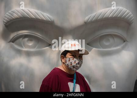 Bangkok, Thailand. 16th Januar 2022. Eine Frau mit Gesichtsmaske als vorbeugende Maßnahme gegen die Ausbreitung von covid-19 geht an einer Skulptur vor der Central World, dem Einkaufszentrum in Bangkok, vorbei. (Foto von Peerapon Boonyakiat/SOPA Images/Sipa USA) Quelle: SIPA USA/Alamy Live News Stockfoto