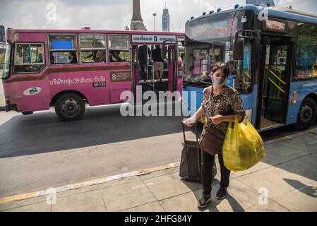Bangkok, Thailand. 16th Januar 2022. Eine Frau, die eine Gesichtsmaske trug, als vorbeugende Maßnahme gegen die Ausbreitung von Covid-19, sah, wie sie an der Bushaltestelle des Siegedenkmals in Bangkok ein Gepäck zog. Kredit: SOPA Images Limited/Alamy Live Nachrichten Stockfoto
