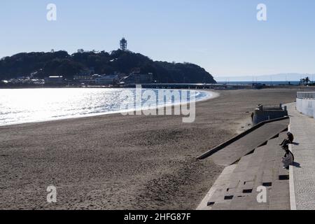 Enoshima, Japan. 16th Januar 2022. In der Nähe des Strandes sitzen Menschen auf Stufen, die unter einer Tsunami-Warnung bis zum Nachmittag in Enoshima leer blieben.Ein riesiger Vulkanausbruch unter Wasser in der Nähe des südpazifischen Inselstaates Tonga löste am Samstagabend Tsunami-Warnungen über den Pazifik aus. Bis zu einem Meter hohe Wellen treffen am frühen Sonntag auf einige Teile der japanischen Küste. Kredit: SOPA Images Limited/Alamy Live Nachrichten Stockfoto