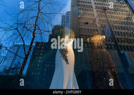 Ein Boutique-Fenster mit Couture-Mänteln spiegelt hohe Gebäude im Pike Pine Retail Core in Seattle am 9. Januar 2022 wider. Stockfoto