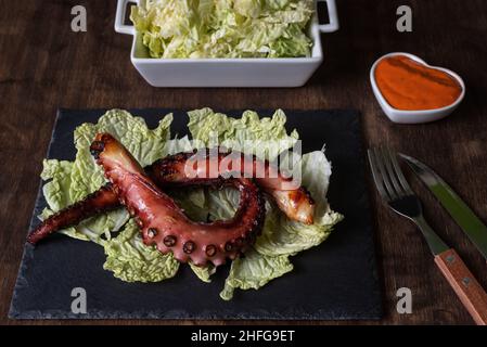 Trockene Krake Beine, nach der Tradition getrocknet, serviert auf einem Bett aus gehacktem Kohl und begleitet von Mojo Picon Sauce.typisches Gericht aus dem tropischen Stockfoto