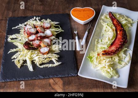 Trockene Krake Beine, nach der Tradition getrocknet, serviert auf einem Bett aus gehacktem Kohl und begleitet von Mojo Picon Sauce.typisches Gericht aus dem tropischen Stockfoto