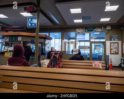 Anacortes, WA USA - ca. November 2021: Blick auf Menschen, die sitzen und stehen und auf die Ankunft einer Washington State Ferry in der Lobby warten. Stockfoto