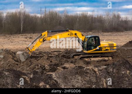 Raupenbagger arbeiten Bodengraben in einem Industriegebiet oder auf einer Baustelle. Stockfoto