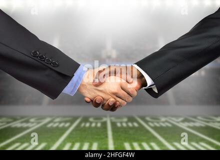 Aufnahme von zwei unverkennbaren Männern, die sich gegenseitig mit einem Händedruck auf ein Geschäft im Fußballsport begrüßen Stockfoto