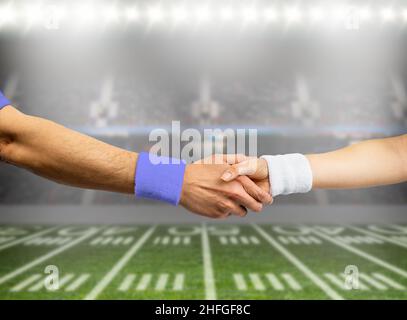 Nahaufnahme von zwei Rugby-Spielern aus gegnerischen Teams, die sich die Hände schüttelten Stockfoto