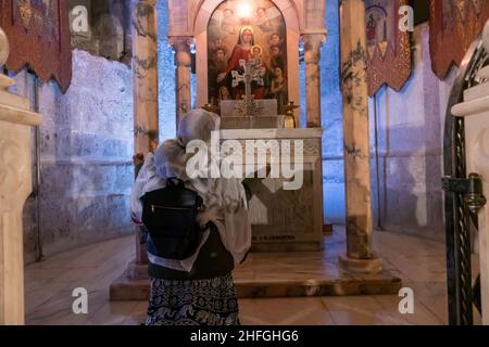 Ein äthiopisch-orthodoxer Christ betet an der armenischen Kapelle der Abteilung des Kleides oder an den Roben in der Grabeskirche in der Altstadt des Christlichen Viertels, Ostjerusalem, Israel Stockfoto