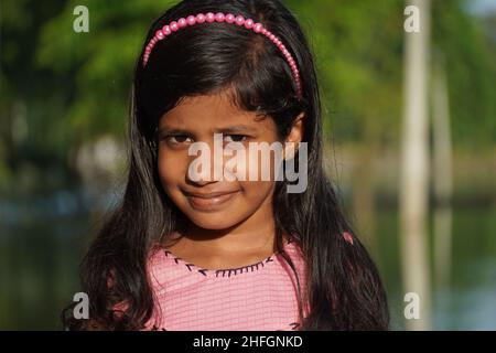 Ein schönes Mädchen in der Kamera zu beobachten und lächeln - Mädchen Bildung Konzept Stockfoto