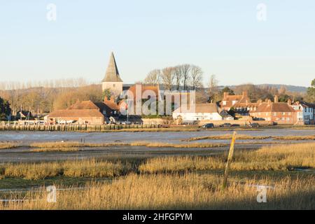 Bosham Dorf und Kirche über Watt und Gräser gesehen, Gezeiten aus. Sunny, blue, Chichester Harbour, West Sussex, England, VEREINIGTES KÖNIGREICH. Januar Stockfoto