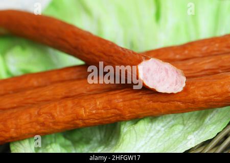 Traditionelle polnische Räucherwurst namens Kabanos auf Salatblättern Stockfoto