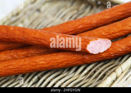 Traditionelle polnische Räucherwürste namens Kabanos auf Korboberfläche in Nahaufnahme Stockfoto