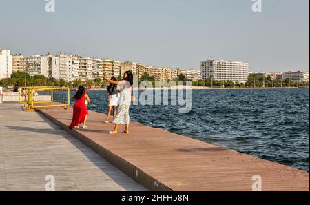 Thessaloniki, Griechenland - 27. Juli 2021: Junge Frauen machen Selfies am Wasser der Stadt. Thessaloniki ist die zweitgrößte Stadt Griechenlands und die Hauptstadt der griechischen Hauptstadt Stockfoto