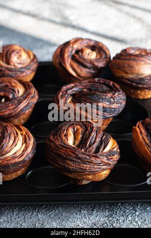 Chocolate Cruffin, ein Hybrid aus einem Croissant und Muffin mit viel Butter, bestreut mit Puderzucker. Stockfoto