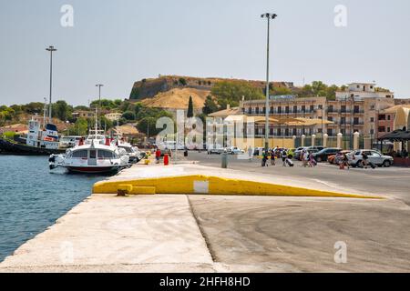 Kerkyra, Korfu, Griechenland - 10. August 2021: Passagiere eilen zum Schiff im Hafenterminal. Neue Festung im Vordergrund. Stockfoto