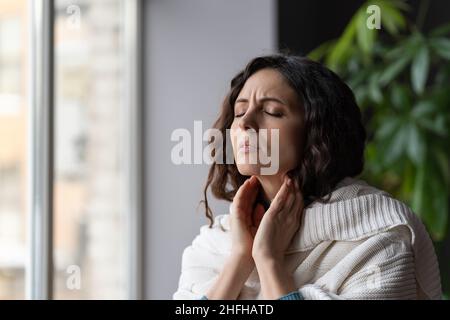 Kranke Frau mit Halsschmerzen Berührung vergrößerte Lymphknoten leiden an Covid-19, Angina oder Pharyngitis Stockfoto