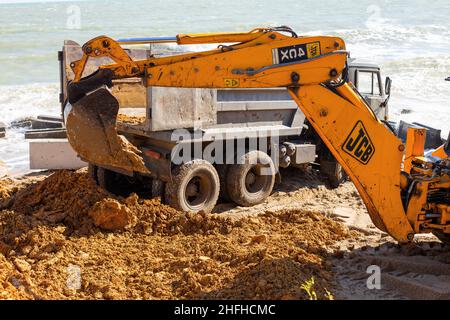 ODESSA, UKRAINE -17 October 2016: Bagger gräbt Sand an einem Meeresstrand. Radladerbagger, der Aushubarbeiten für den Bau von Stadtentw Stockfoto