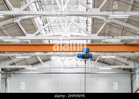 Deckenbalken oder Brückenkran im Hangargebäude des Industrielagers. Stockfoto