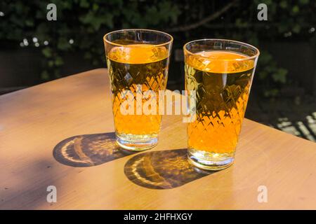 cidre-Gläser stehen auf einem Outdoor-Tisch in der Sonne als Symbol für hesse-Cidre namens apfelwein Stockfoto