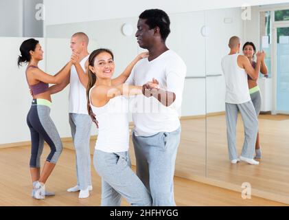 Junge Paare üben aktiven Tanz zu zweit Stockfoto