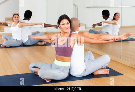 Athletische koreanische Frau, die mit einem männlichen Partner paarweise Yoga-Übungen durchführt Stockfoto