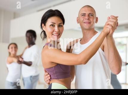 Junge Paare üben aktiven Tanz zu zweit Stockfoto