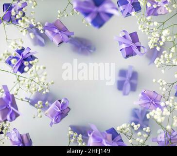 Eine mehrschichtige Postkarte aus Geschenkschachteln in einer modischen, trendigen, sehr perifarbenen Farbe mit weißen Blüten auf einem nebligen Hintergrund. Happy Women Day und Val Stockfoto