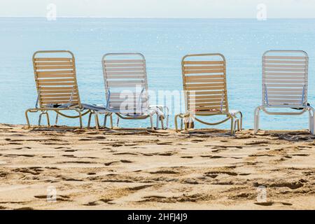 Eine Reihe von drei Strandliegen mit Blick auf das Meer Stockfoto