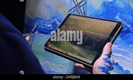 Artist kopist Farbe Marine mit Schiff im Ozean. Handwerker Dekorateur zeichnen wie Boot segeln am blauen Meer mit Acryl Farbe. In der Hand von tablet pc. Stockfoto