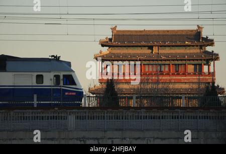 (220117) -- PEKING, 17. Januar 2022 (Xinhua) -- Eine Eisenbahnlokomotive fährt an den Yongdingmen (Tor des ewigen Friedens) in Peking, der Hauptstadt Chinas, am 17. Januar 2022 vorbei. Die Zahl der Eisenbahnpassagierfahrten während des bevorstehenden Reisesturms auf dem Frühlingsfest in China wird voraussichtlich um 28,5 Prozent gegenüber der Vorsaison im vergangenen Jahr steigen, zeigen Branchendaten. Die Reisestreise des Frühlingsfestes 2022 dauert vom 17. Januar bis 25. Februar. Während der 40-tägigen Reisesaison, auch bekannt als chunyun, werden viele Chinesen reisen, um ihre Familien zum Chinesischen Mondneujahr oder Frühlingsfest zu treffen, das im Herbst stattfinden wird Stockfoto