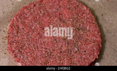 Kochen macht Fleisch Medaillons für Burger. Koch in schwarz Handschuhe macht Schnitzel essen. Die koteletts sind in Stahl Ring in eine noch Medaillon eingeebnet. Stockfoto