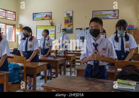 DENPASAR,BALI-OCT 05 2021: Schüler der Mittelstufe beten gemeinsam, um in der Schule zu lernen. Indonesien begann Anfang 20 mit der Eröffnung von Schulen Stockfoto