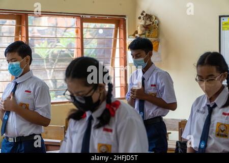 DENPASAR,BALI-OCT 05 2021: Schüler der Mittelstufe beten gemeinsam, um in der Schule zu lernen. Indonesien begann Anfang 20 mit der Eröffnung von Schulen Stockfoto