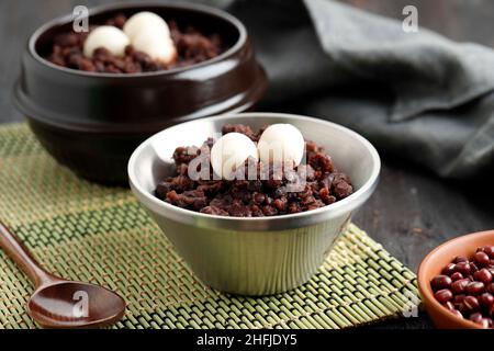 Koreanischer Dongji-Porridge mit roten Bohnen und Reiskuchen auf Edelstahlschüssel Stockfoto