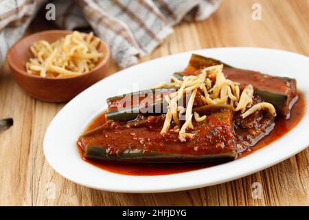 Terong Balado, gebratene Aubergine serviert mit Tomate und Chili Paste mit knusprigen Sardellen auf der Oberseite. Balado Terong ist in Indonesien beliebt für Tagesmenüs Stockfoto