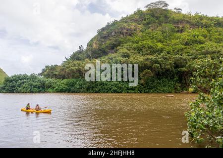 Kauai, Hawaii - 9. Dezember 2021: Malerische tropische Landschaft in der Nähe des Wailua Flusses und des Kamokila Hawaiian Village auf der Kauai Insel, Hawaii. Leute Kajakfahren o Stockfoto