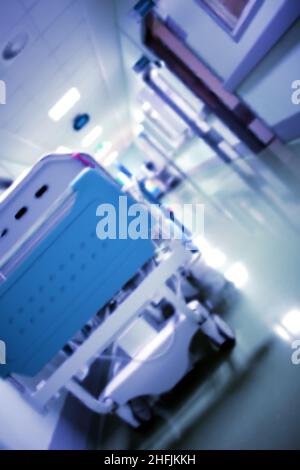 Modernes Radbett im langen Krankenhausfoyer, unfokussierter Hintergrund. Stockfoto