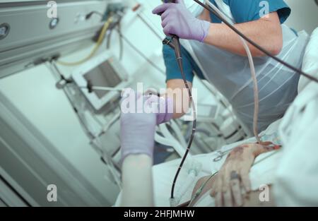 Zusammenarbeit von Ärzten während der endoskopischen Operation auf der Patientenstation. Stockfoto