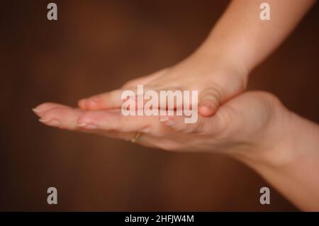 Mutter hält ihre Kinderhand Stockfoto
