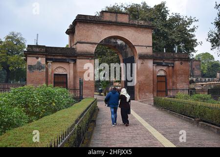 29. Dezember 2021 Lucknow, Uttar Pradesh, Indien. Touristenpaar zu Fuß schleckt Bailey Guard Gate an der britischen Residenz. Gebaut von Nawab Asaf Ud-Daul Stockfoto