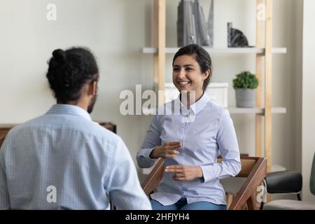 Lächelnde indische Frau, die mit einem Freund Gebärdensprache übt. Stockfoto